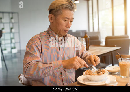 matured asian business male having breakfast Stock Photo