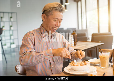 matured asian business male having breakfast Stock Photo