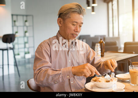 matured asian business male having breakfast Stock Photo