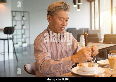 matured asian business male having breakfast Stock Photo