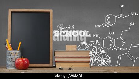 Digital composite of Books on the table against grey blackboard with education and school graphics