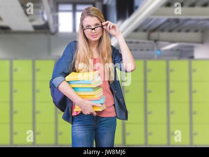 Digital composite of female student holding books in front of lockers Stock Photo