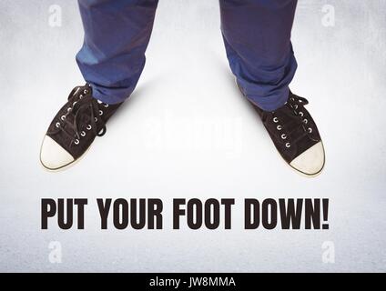 Digital composite of Put your foot down text and Black shoes on feet with grey background Stock Photo