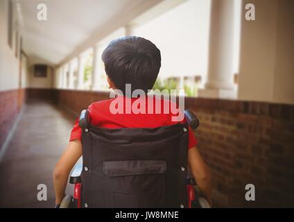 Digital composite of Disabled boy in wheelchair in school corridor Stock Photo