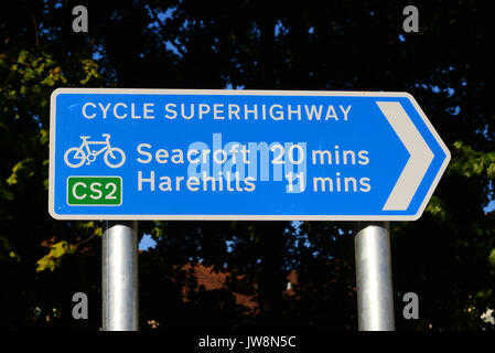 cyclist by direction and distance sign on leeds cycling super highway leeds Yorkshire UK Stock Photo