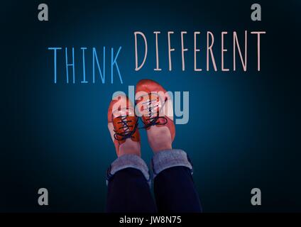 Digital composite of Think Different text and red shoes on feet with blue background Stock Photo