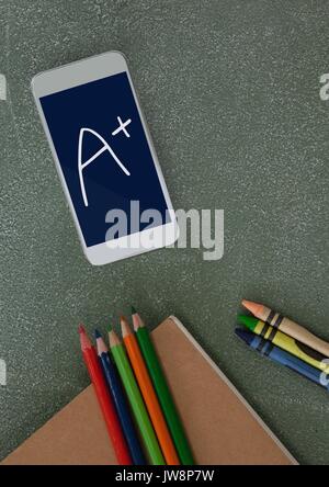 Digital composite of Phone on a school table with A+ text on screen Stock Photo