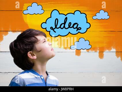 Digital composite of Boy looking at colorful idea clouds graphics Stock Photo