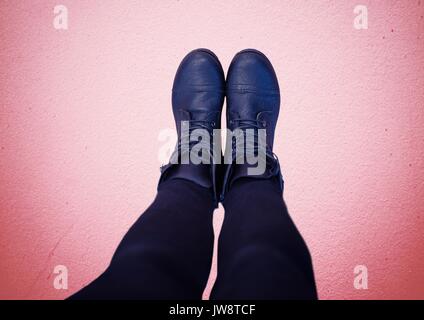 Digital composite of Blue shoes on feet with red background Stock Photo