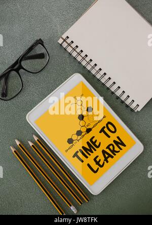 Digital composite of Tablet on a school table with school icons on screen Stock Photo