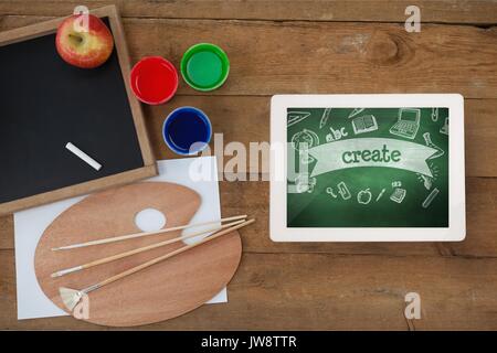 Digital composite of Tablet on a school table with school icons on screen
