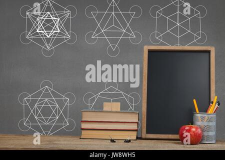 Digital composite of Books on the table against grey blackboard with education and school graphics Stock Photo