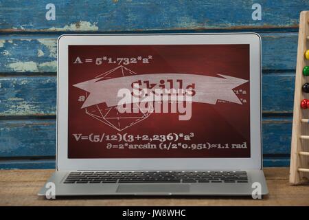 Digital composite of Computer on a school table with school icons on screen Stock Photo