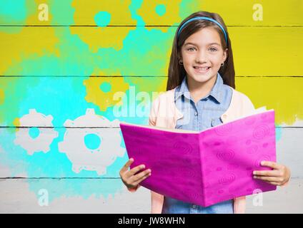 Digital composite of Girl holding book in front of yellow painted wall with cog gear settings Stock Photo