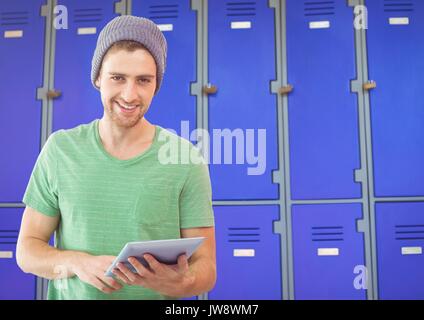 Digital composite of male student holding tablet in front of lockers Stock Photo