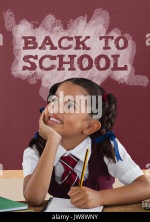 Digital composite of Happy student girl at table against red blackboard with back to school text Stock Photo