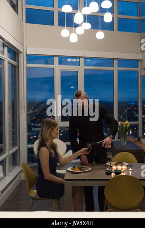 Couple having candlelight dinner in living room at home Stock Photo