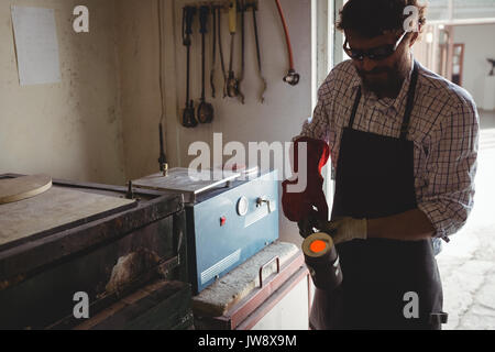Craftsman holding melted metal in workshop Stock Photo