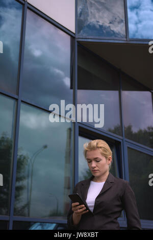 University student using mobile phone in campus Stock Photo