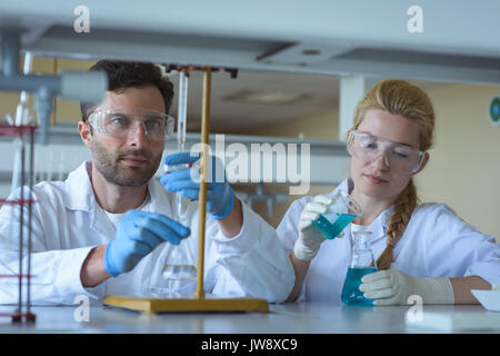 Attentive university students doing a chemical experiment in laboratory Stock Photo