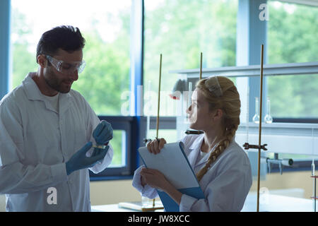 Attentive university students doing a experiment in laboratory Stock Photo