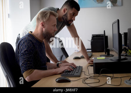 Colleagues working together at desk in office Stock Photo