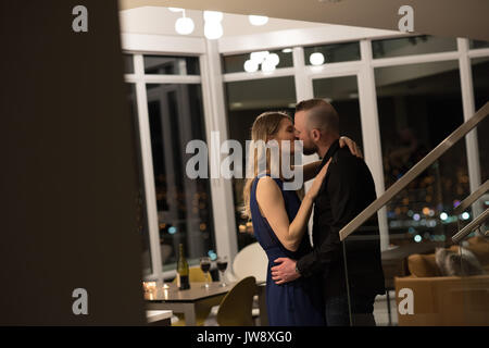 Romantic couple kissing each other in living room at home Stock Photo