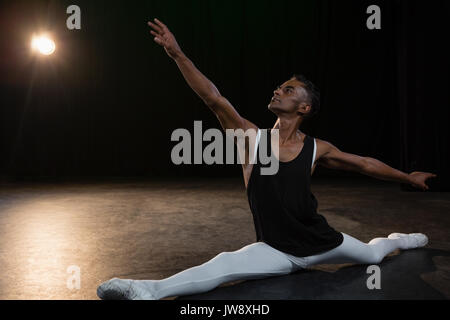 Ballet dancer performing a split in the stage Stock Photo