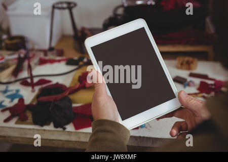 Mid-section of craftsman using digital tablet in workshop Stock Photo