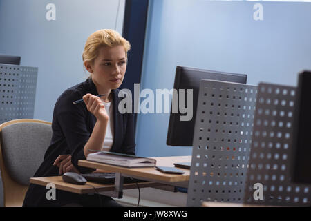 Pretty female university student working on laptop in cafe, writing ...