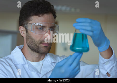 Attentive university student doing a chemical experiment in laboratory Stock Photo