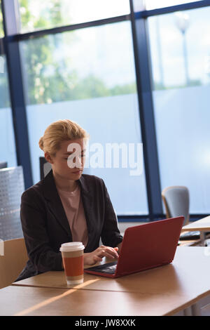 Attentive university student using laptop in college Stock Photo