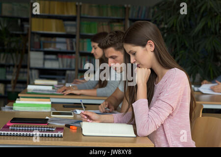 College students studying at desk in classroom Stock Photo