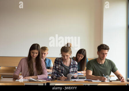 Students studying at desk in classroom Stock Photo