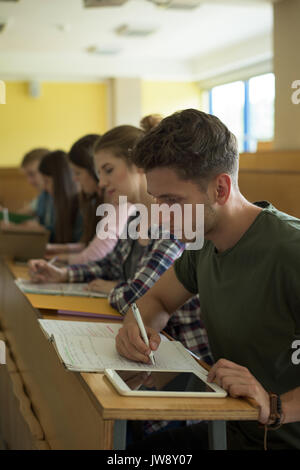 Young university students studying at desk in classroom Stock Photo
