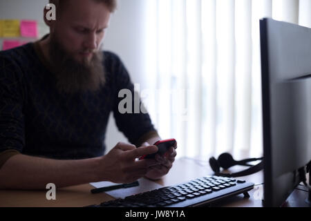 Executive using mobile phone at desk in office Stock Photo