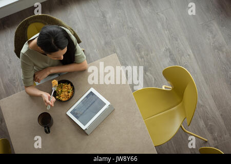 Top view of woman using laptop while having breakfast Stock Photo