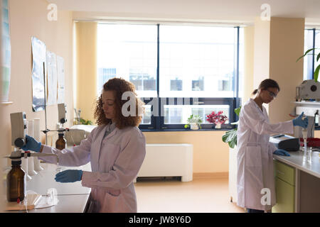 Female students performing chemistry experiment in lab Stock Photo