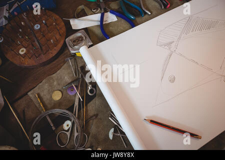 Various tools and sketch paper on worktop in workshop Stock Photo