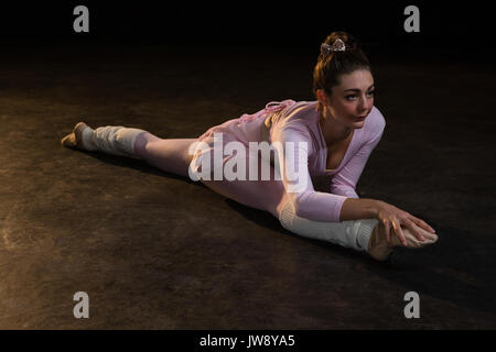 Female ballet dancer stretching before dancing in the studio Stock Photo