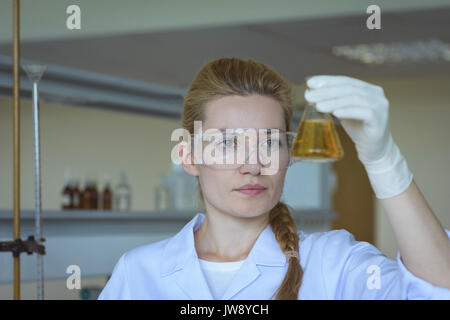 Attentive university student doing a chemical experiment in laboratory Stock Photo