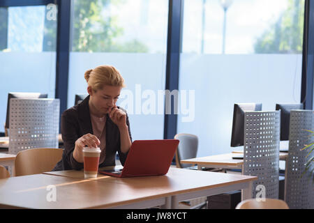 Attentive university student using laptop in college Stock Photo