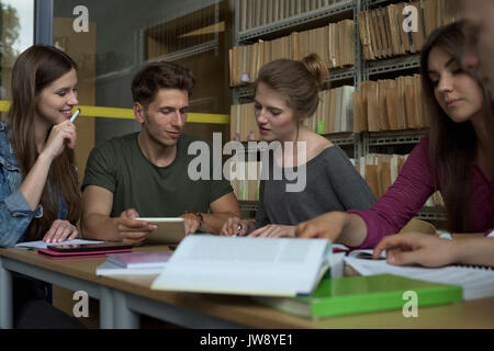College students studying at desk in library Stock Photo