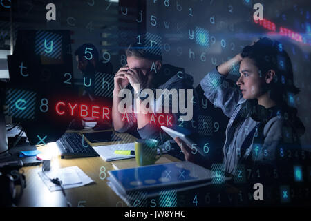 Tensed colleagues sitting at desk in office Stock Photo