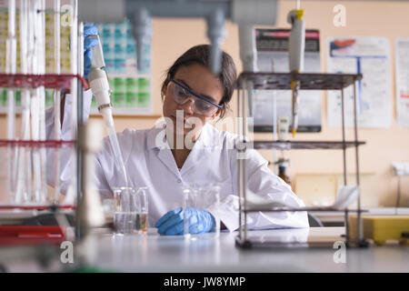 Teenage girl performing experiment in chemistry lab Stock Photo