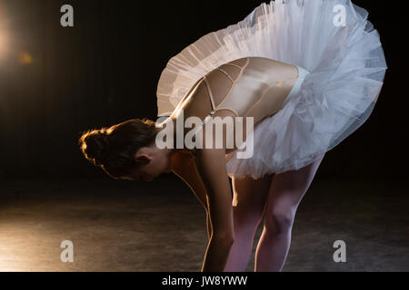 Female ballet dancer stretching before dancing in the studio Stock Photo