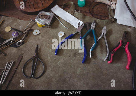 Various metal tools on wooden table in workshop Stock Photo