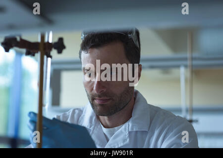Attentive university student doing a chemical experiment in laboratory Stock Photo