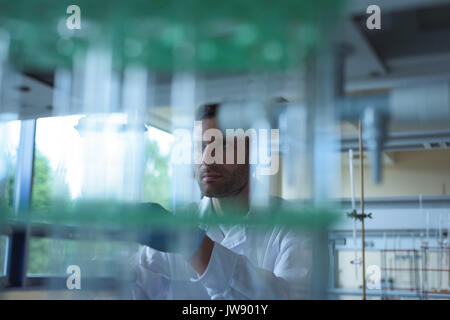 Attentive university student doing a chemical experiment in laboratory Stock Photo