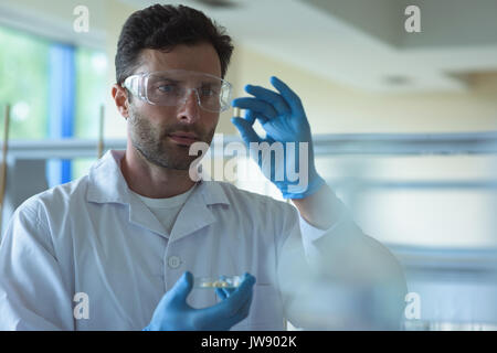 Attentive university student doing a experiment in laboratory Stock Photo